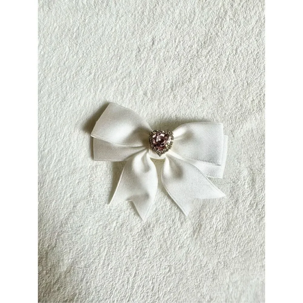 White bow hair clip with pink rhinestone heart ￼